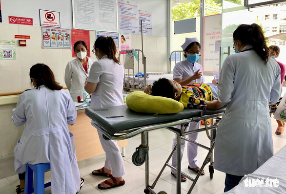 Bác sĩ, điều dưỡng khoa cấp cứu Bệnh viện Nhi đồng 2 (TP.HCM) tiếp nhận và đánh giá tình trạng sức khỏe ban đầu của một bệnh nhi cần cấp cứu - Ảnh: XUÂN MAI