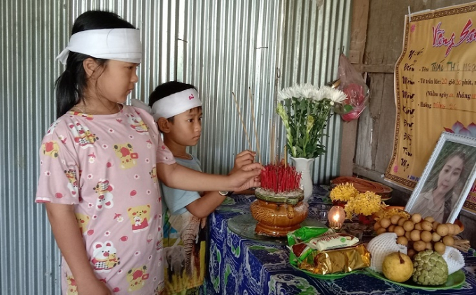 Bé Thái Thị Lan Anh (9 tuổi, bìa trái) và Thái Bảo (6 tuổi, con của chị T.T.N.L) đốt nhang cho mẹ, nhân ngày thất đầu tiên TRẦN NGỌC