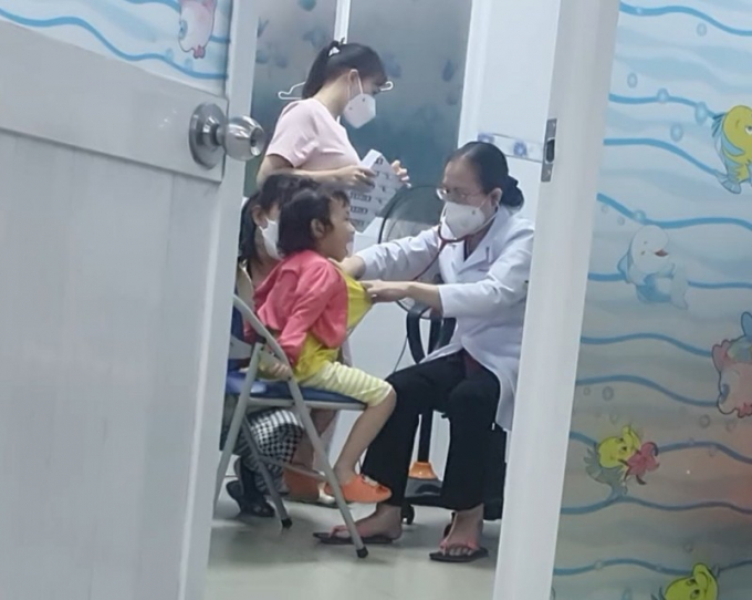 Người phụ nữ ở phòng khám số 2 được cho là bác sĩ bác sĩ CKI Phạm Thị Thu Hồng không đeo bảng tên đang khám bệnh cho bệnh nhi.