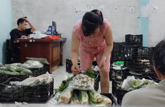 Công nhân dán tem VietGAP vào gói rau mua từ chợ đầu mối đã được sơ chế. Ảnh: Bông Mai/Tuổi Trẻ.