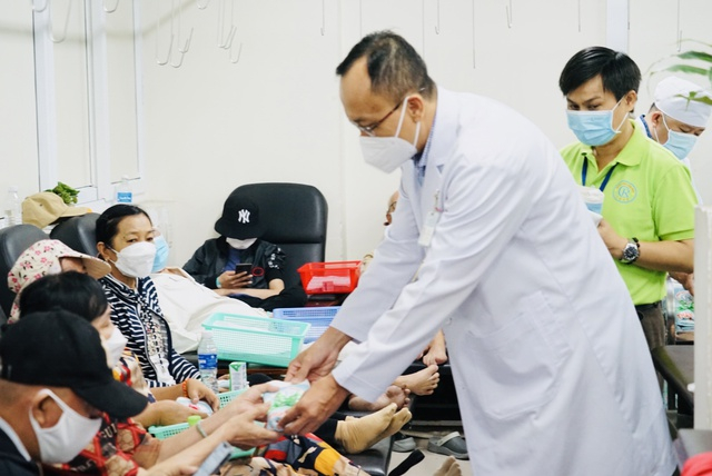 TS.BS Lê Tuấn Anh - Giám đốc Trung tâm Ung bướu, Bệnh viện Chợ Rẫy trao quà cho bệnh nhân. Ảnh: Kim Vân.