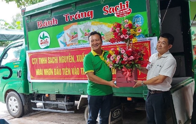 Phó Chủ tịch UBND TX Hoài Nhơn Phạm Văn Chung (bên phải) tặng hoa chúc mừng Công ty TNHH Sachi Nguyễn. Ảnh: HẢI YẾN