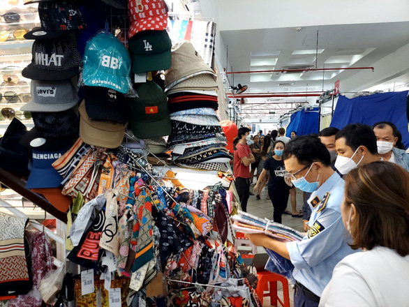 Cơ quan chức năng tiến hành thanh tra, kiểm tra các điểm buôn bán tại Sài Gòn Square - Ảnh: QLTT