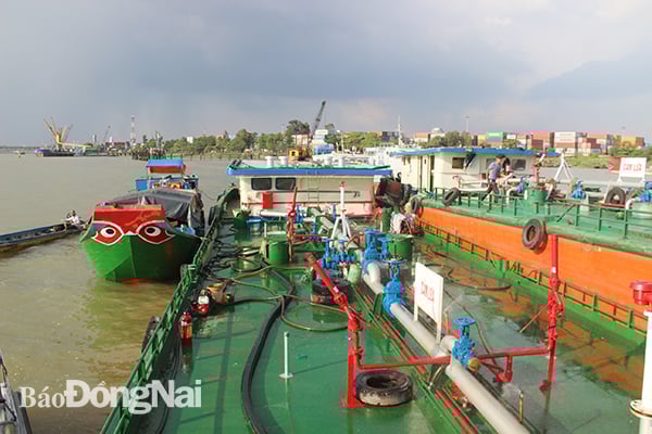 Để bán trộm xăng, các đối tượng cho ghe cập sát mạn tàu Thành Lễ 2 (bên phải)