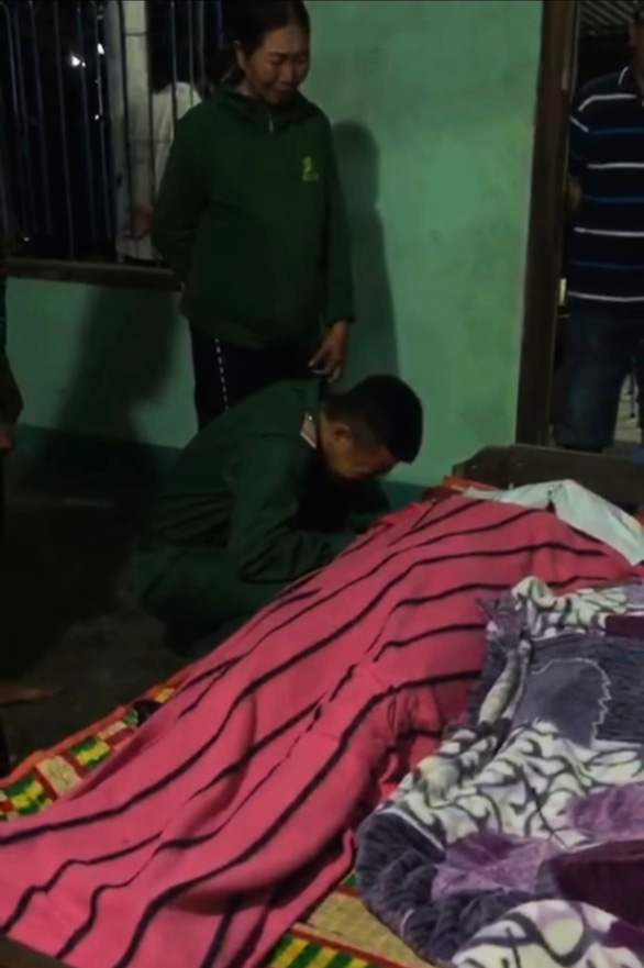 Em Nguyễn Đăng Khiêm trong bộ quân phục gục khóc bên thi thể mẹ và hai em - Ảnh cắt từ clip