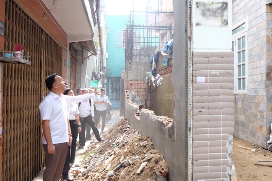 Chủ tịch UBND quận Phú Nhuận Nguyễn Đông Tùng thăm hỏi, động viên các gia đình hiến đất mở rộng hẻm 694 Nguyễn Kiệm. Ảnh: THU HƯỜNG