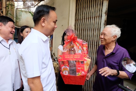 Chủ tịch UBND quận Phú Nhuận Nguyễn Đông Tùng thăm hỏi, tặng quà gia đình ông Trần Văn Hùng - hộ đã hiến gần 11m2 đất để mở rộng hẻm. Ảnh: THU HƯỜNG