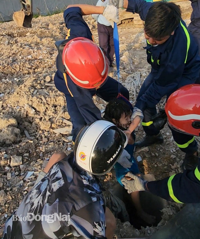 Lực lượng cứu nạn, cứu hộ giải cứu bé L.K.T. (5 tuổi, ngụ TT.Hiệp Phước, H.Nhơn Trạch) khỏi hố cọc ép bê tông chiều 19-12. Ảnh: CTV