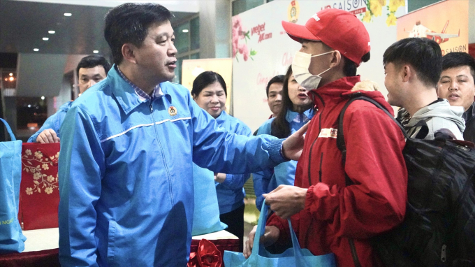 Ông Kha Văn Tám - Chủ tịch Liên đoàn Lao động tỉnh Nghệ An - trao quà cho công nhân lao động trở về từ miền Nam tại sân bay quốc tế Vinh. Ảnh: Quỳnh Trang