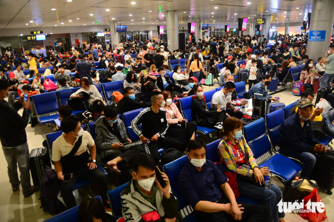 Hành khách ngồi chờ ra máy bay ở sân bay Tân Sơn Nhất - Ảnh: QUANG ĐỊNH