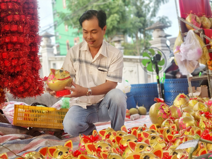 Anh Văn Tuấn thường mua sản phẩm tạo hình linh vật từ trái dừa của anh Trương Quốc Kỳ. Ảnh: Hoàng Lộc
