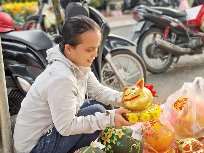 Chị Võ Thị Ngọc Thi thích thú với linh vật mèo được làm từ trái dừa tươi. Ảnh: Văn Sỹ