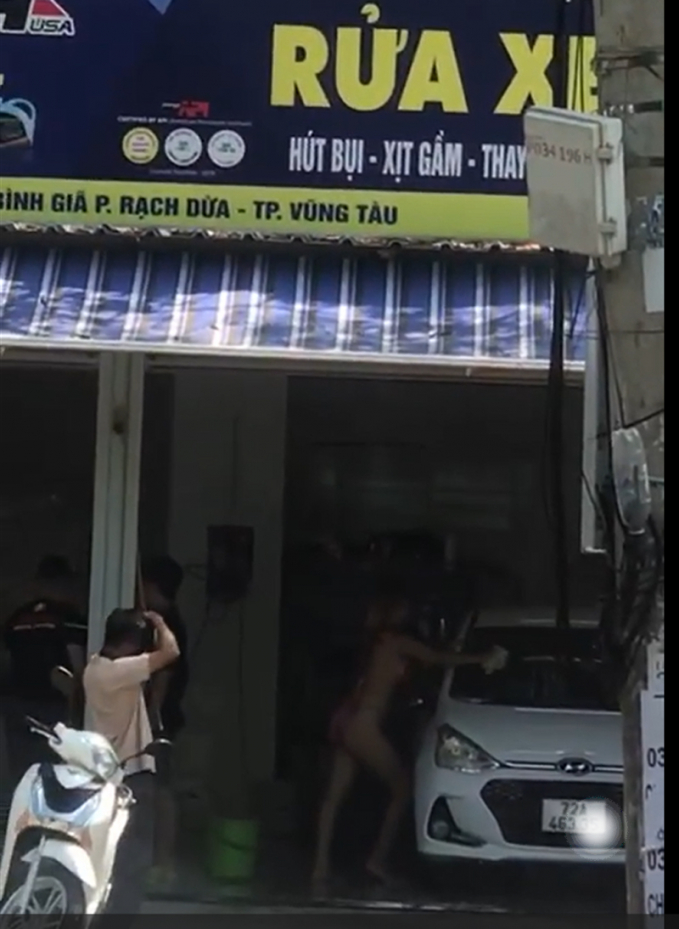 Hình ảnh cô gái mặc bikini rửa xe gây phản cảm. Ảnh cắt từ clip.