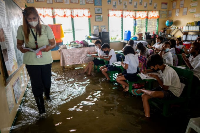 Lớp học ở Philippines ngập nước do triều cường hồi tháng 8/2022. Ảnh: Reuters.