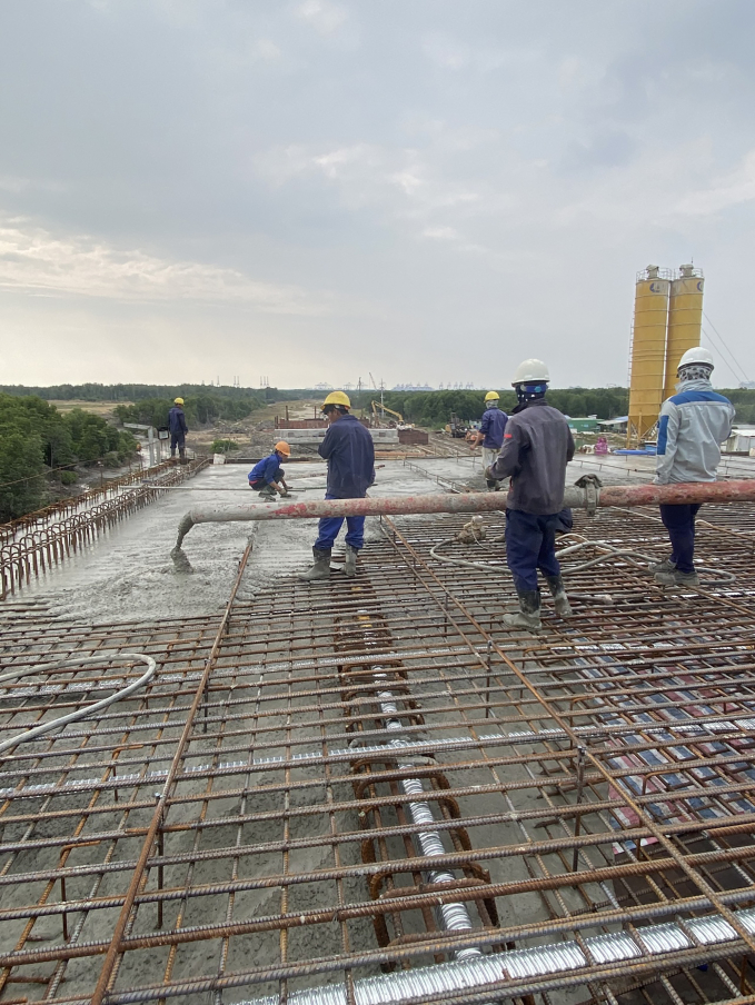 Các nhà thầu đang đẩy nhanh thi công đường 911B. Trong ảnh: Công nhân thi công dầm cầu Mỏ Nhát.