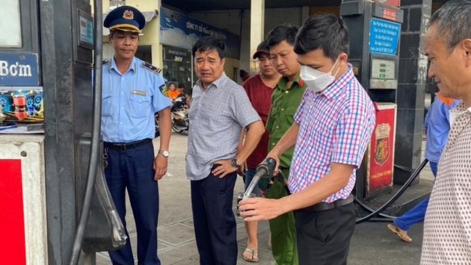 Lấy mẫu xăng tại cột đo xăng của Công ty Cổ phần Sao Mai Sài Gòn đi thử nghiệm (Ảnh: QLTT).