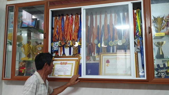 Ông Nguyễn Văn Vinh giới thiệu về gia tài đồ sộ là những huy chương, giấy khen, huân chương của người con trai út là tuyển thủ bơi lội.