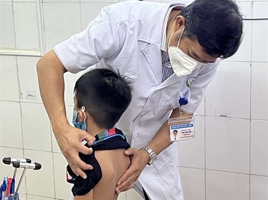 Bé trai bị gù vẹo cột sống được bác sĩ thăm khám