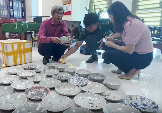 Các chuyên gia giám định số cổ vật gốm sứ do nhóm ngư dân khai thác trái phép ở vùng biển xã Bình Hải, huyện Bình Sơn. Ảnh: T.Tanh.