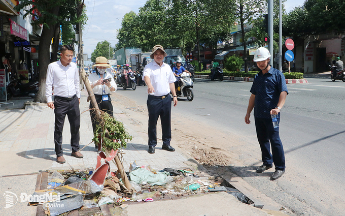 Đoàn công tác thị sát một hố ga thu nước trên đường Đồng Khởi bị phủ kín bởi rác thải sinh hoạt