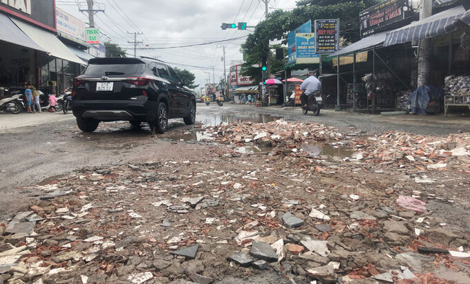 Đường Bùi Thị Xuân bị xuống cấp, ngập nước, người dân phải dùng vật liệu lấp các hố sâu để tránh TNGT