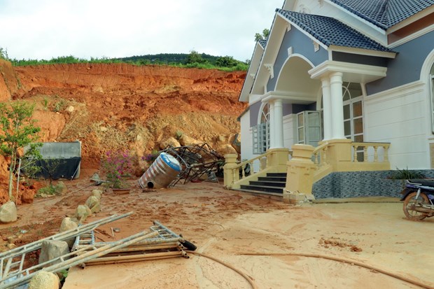 Đất đá từ ta luy dương sạt lở xuống phía sau căn nhà ven hồ. Ảnh: Nguyễn Dũng-TTXVN