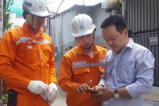 Công nhân điện lực TP HCM hướng dẫn khách hàng kiểm tra chỉ số điện