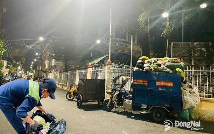 Công nhân thu gom rác vào ban đêm tại TP.Biên Hòa. Ảnh: P.Liễu