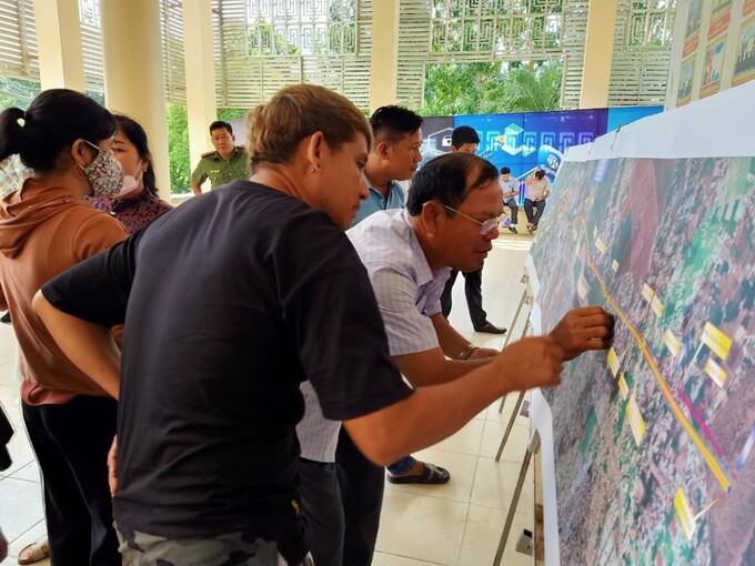 Người dân tranh thủ lúc giải lao Hội nghị tìm hiểu chi tiết các quy định của dự án cao tốc Biên Hòa - Vũng Tàu.