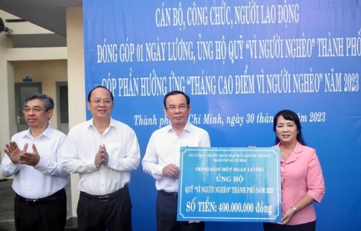 Ủy viên Bộ Chính trị, Bí thư Thành ủy TP HCM Nguyễn Văn Nên trao bảng tượng trưng kinh phí đóng góp 1 ngày lương ủng hộ Quỹ