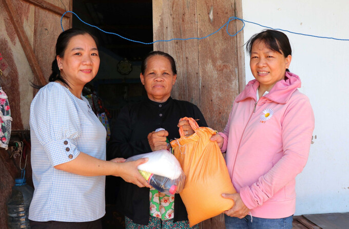 Các hội viên Chị hội Phụ nữ thôn Hiệp Hòa trao quà cho một hộ dân có hoàn cảnh khó khăn.