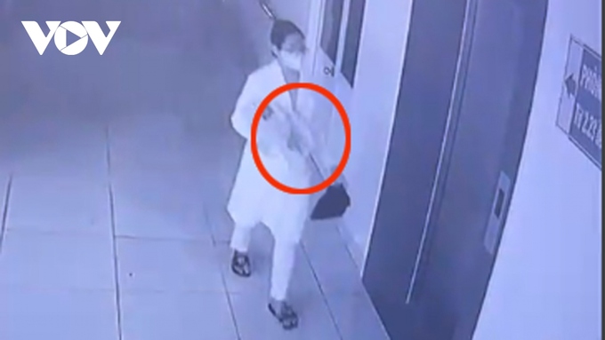 Thắm giả bác sĩ bế cháu bé đi (ảnh cắt từ camera bệnh viện)
