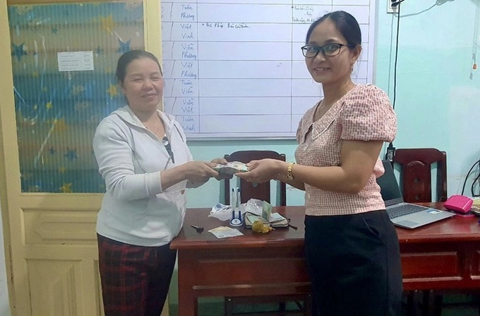 Chị Soa (bên phải) trả lại tiền, vàng cho người đánh rơi - Ảnh: Công an cung cấp