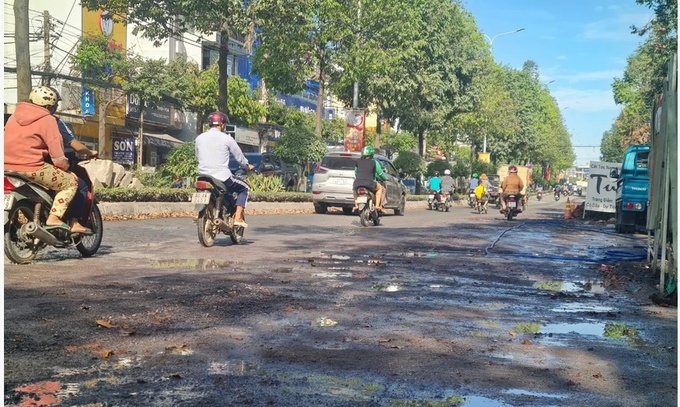 Mặt đường nước chảy trơn trượt gây khó khăn cho người tham gia giao thông.