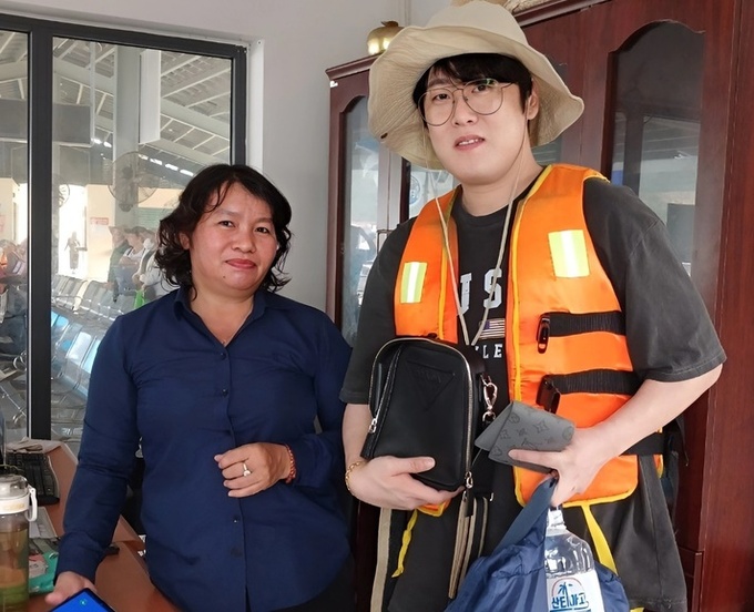 Nam du khách Hàn Quốc nhận lại túi và số tiền từ chị Quỳnh - Ảnh: BQL bến tàu du lịch Nha Trang