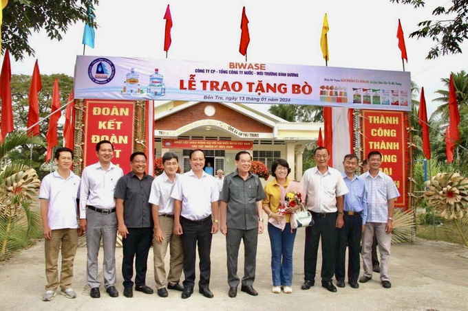 Ông Nguyễn Văn Thiền (đứng giữa) và lãnh đạo địa phương trao bò giống sinh sản cho các hộ nghèo ở huyện Ba Tri