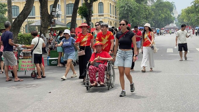 Nhiều người cao tuổi dù đi lại khó khăn nhưng vẫn được con cháu quan tâm, đưa ra phố bằng xe lăn để cùng chung vui trong ngày đại lễ.