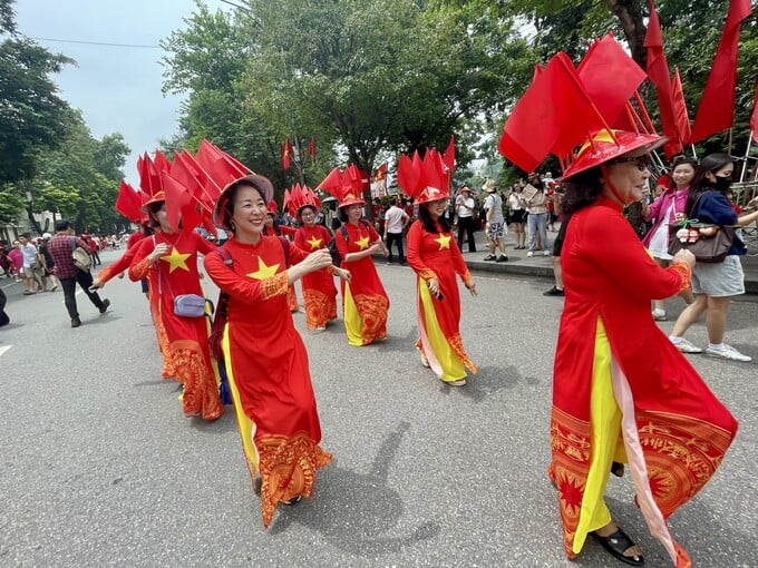 Các bà, các cô diện áo dài cờ đỏ sao vàng.