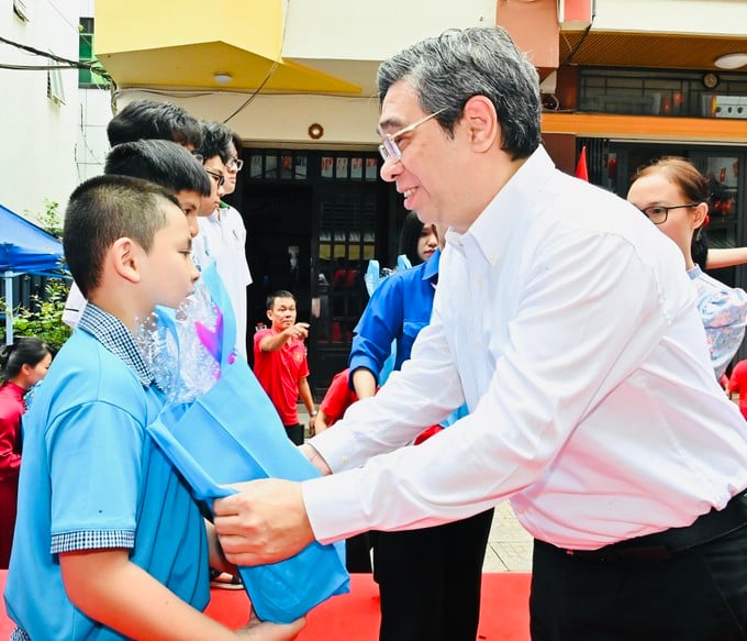 Đồng chí Nguyễn Phước Lộc tặng quà các em học sinh. Ảnh: VIỆT DŨNG