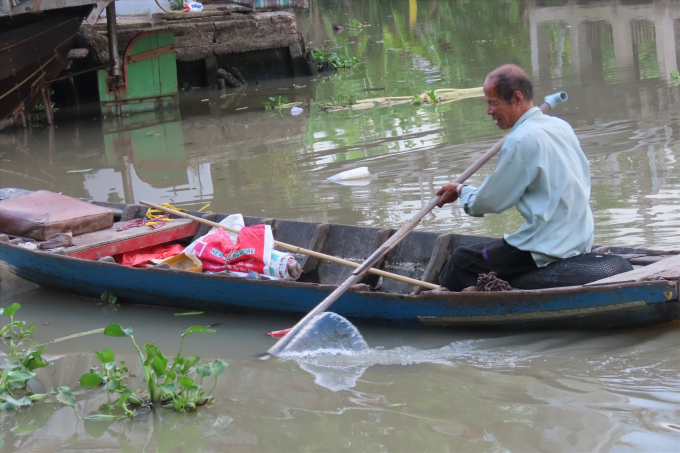 Ông Tuốt đang vớt rác trên sông. Ảnh: S.H