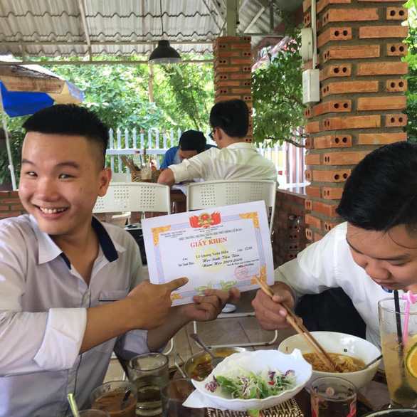 Khoe giấy khen với người đang ăn sáng