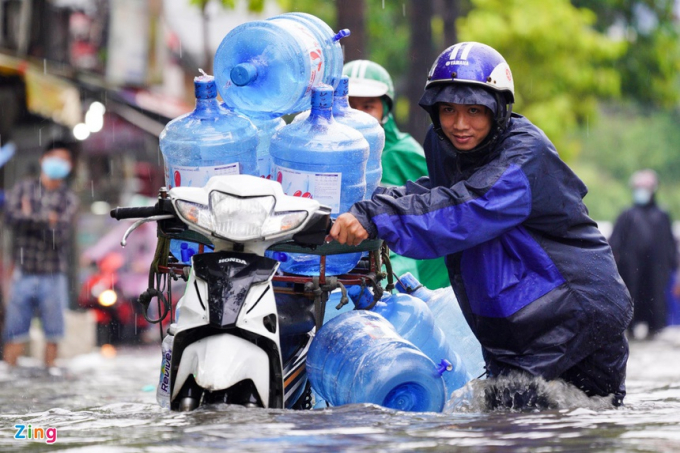 Người dân vật lộn trong biển nước Nguyễn Hữu Cảnh sau cơn mưa. Ảnh: Lê Quân - Chí Hùng.