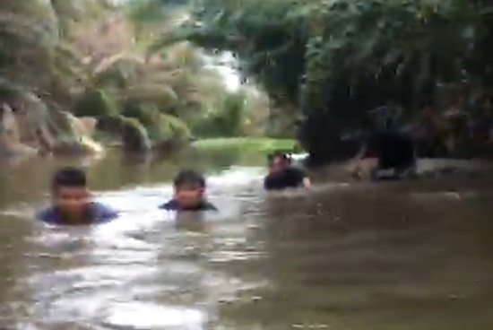 Các chiến sĩ cảnh sát lội bùn, bơi trên rạch để tiếp cận sới bạc (Ảnh: CQĐT)
