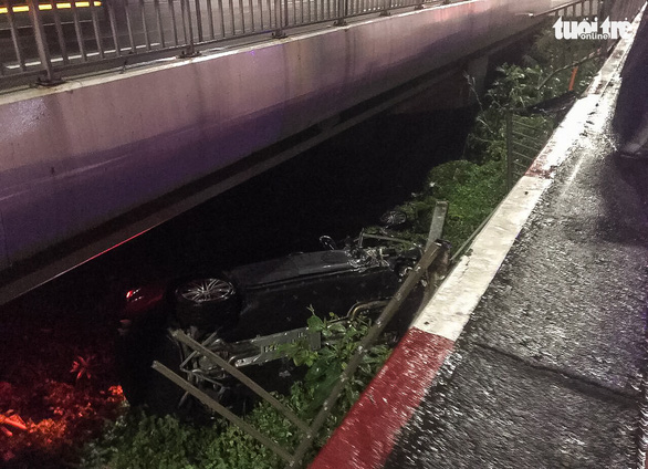 Chiếc ôtô tông sập lan can rơi xuống cầu Sài Gòn - Ảnh: CTV