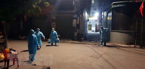 Lực lượng chức năng phun khử khuẩn khu vực bệnh nhân COVID-19 sinh sống. (Ảnh: TTXVN phát)