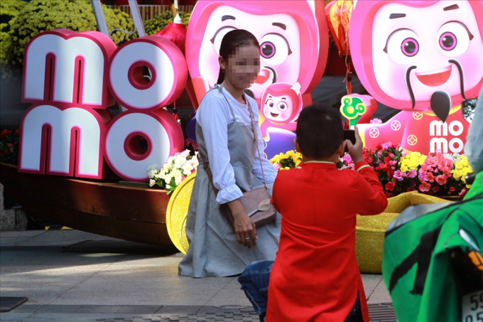 Nhiều người đến chụp ảnh ở trung tâm thương mại Sài Gòn Center (quận 1, TPHCM) lơ là đeo khẩu trang bất chấp việc có thể bị phạt nặng.