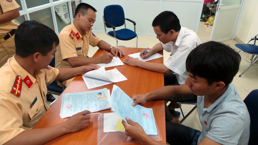 Lái xe Lưu Văn Tuấn (áo màu ghi) làm việc với cán bộ Phòng PC67 - CATP Hà Nội.