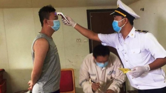 Lực lượng y tế đo thân nhiệt, kiểm tra y tế các thuyền viên trên tàu Amoy Dream. Ảnh: Nguyễn Đức