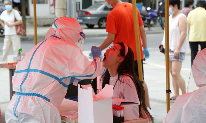 Nhân viên y tế lấy mẫu xét nghiệm nCoV tại thành phố Đại Liên, tỉnh Liêu Ninh, hôm 27/7. Ảnh: AFP.
