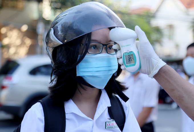 Nữ sinh trường THPT Lý Tự Trọng ở Nha Trang đo thân nhiệt trước khi vào lớp để phòng chống dịch. Ảnh: Xuân Ngọc.